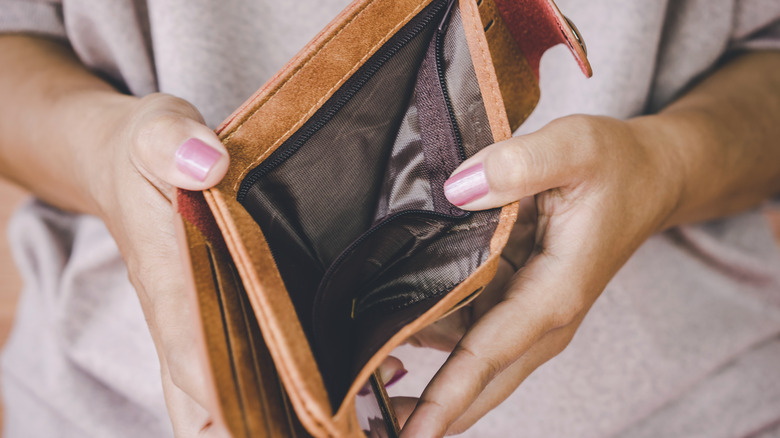 A woman holding an empty wallet