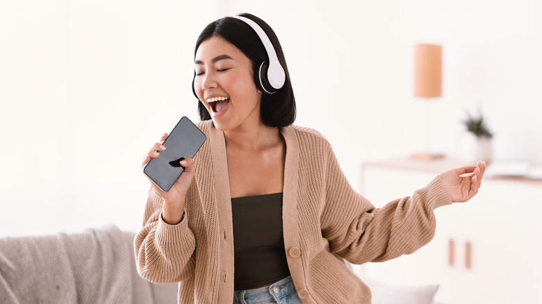 Woman singing into smartphone