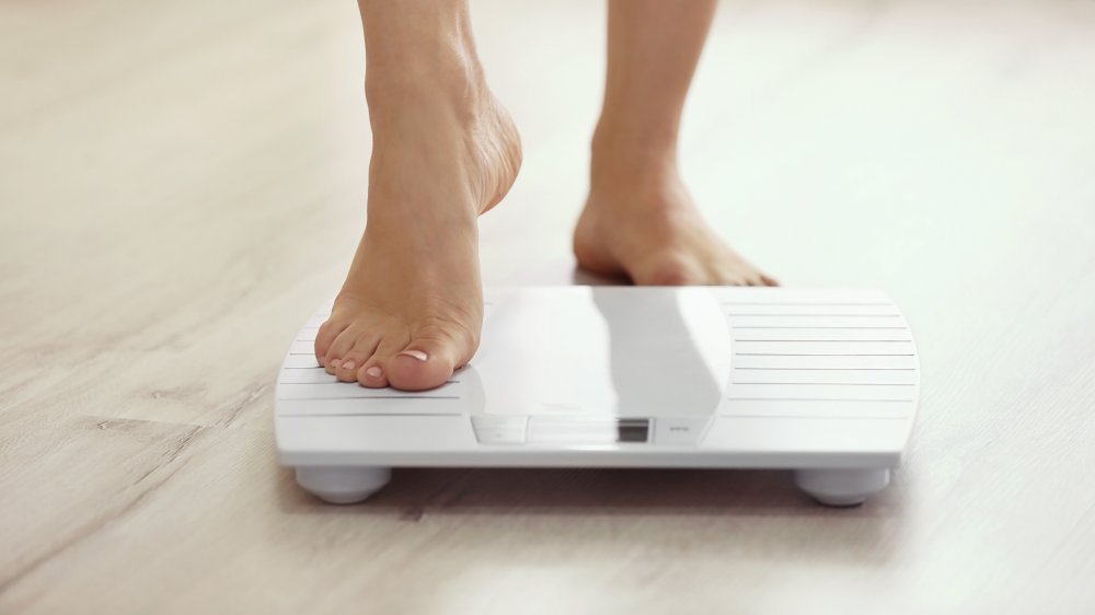 woman stepping onto a scale