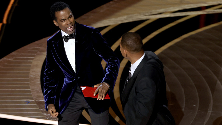 Chris Rock reacts to being slapped by Will Smith onstage at the Oscars