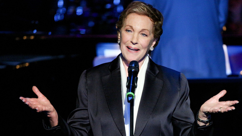 Julie Andrews talking into a mic onstage