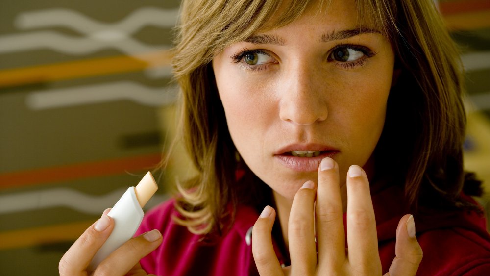 Woman applying chapped lip treatment