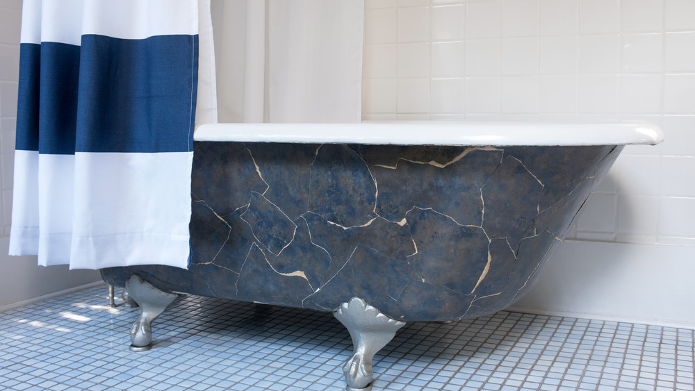 bathtub with shower curtain on a tile floor 