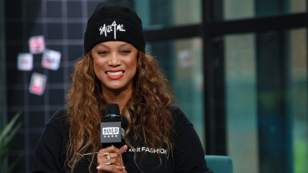 Tyra Banks holding a microphone on her canceled celebrity talk show