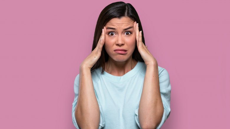 Woman making unsure expression and procrastinating