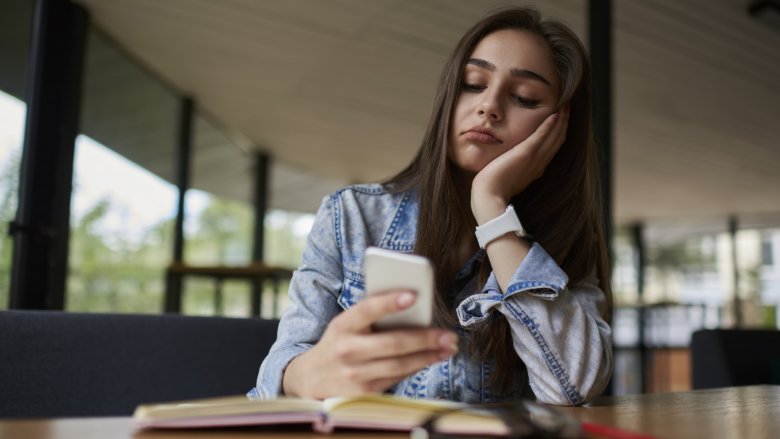 woman procrastinating on cell phone