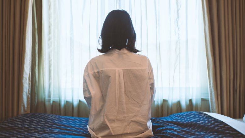 woman sitting alone on bed