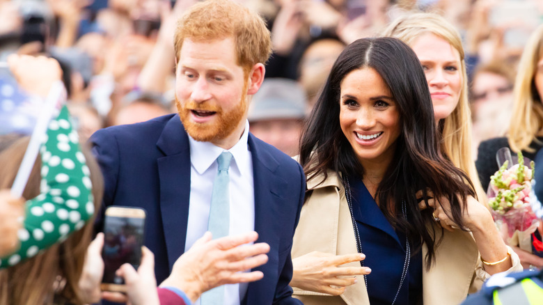 Prince Harry and Meghan Markle in a large crowd of fans