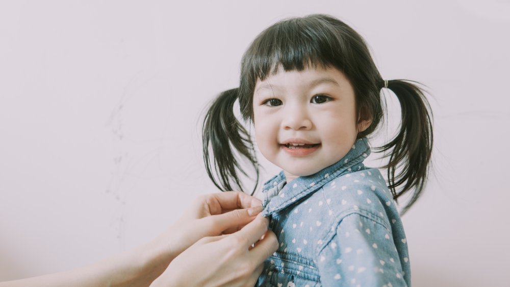 Child getting her shirt buttoned up