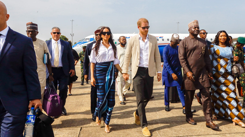 Prince Harry and Meghan Markle walking with crowd