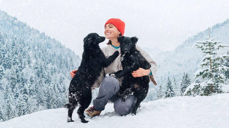 Woman playing with her dogs in the snow