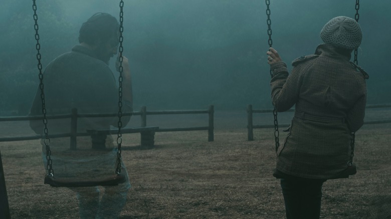 two people sitting on swings