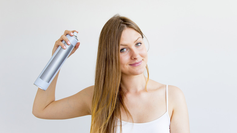 Woman spraying her hair