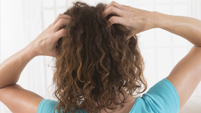 Woman itching her scalp