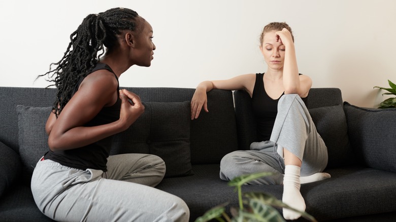 Two women upset and arguing on couch