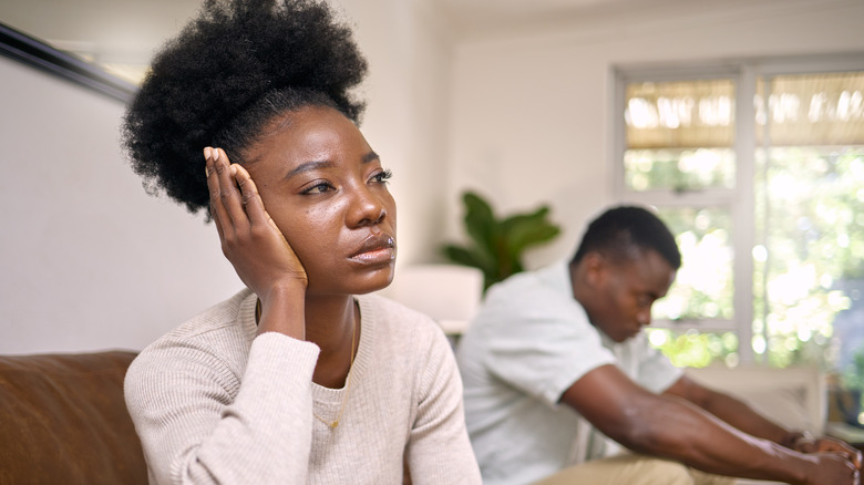 Man and woman sitting apart on couch