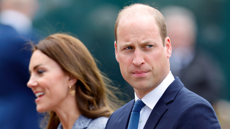 Prince William looks grumpy with Kate Middleton in the background