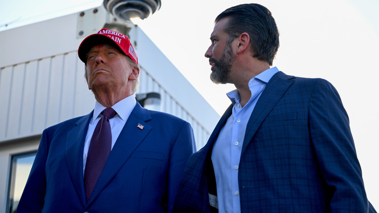 Donald Trump scowling while Donald Trump Jr. looks at him