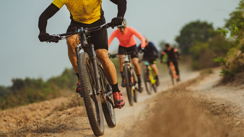 Athletic men bicycling in dirt