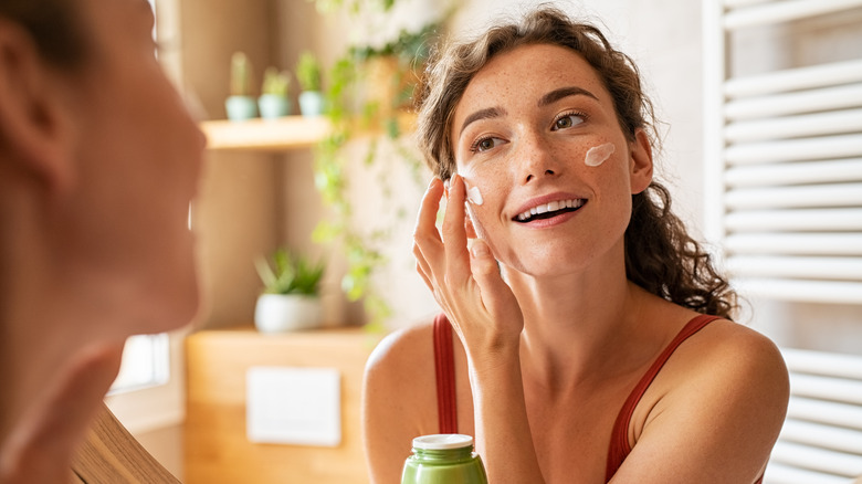 woman applying moisturizer