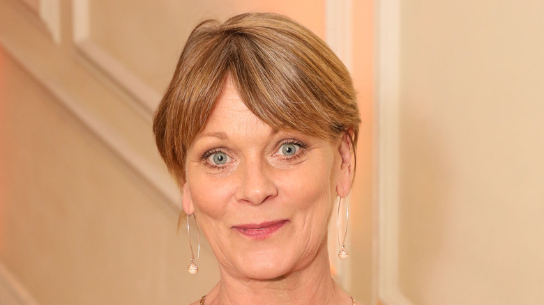 Samantha Bond smiling, wearing large hoops