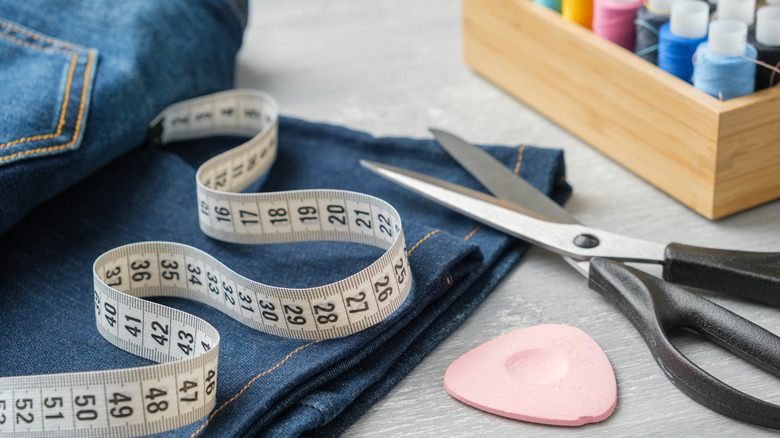 Measuring tape, chalk, and scissors with jeans