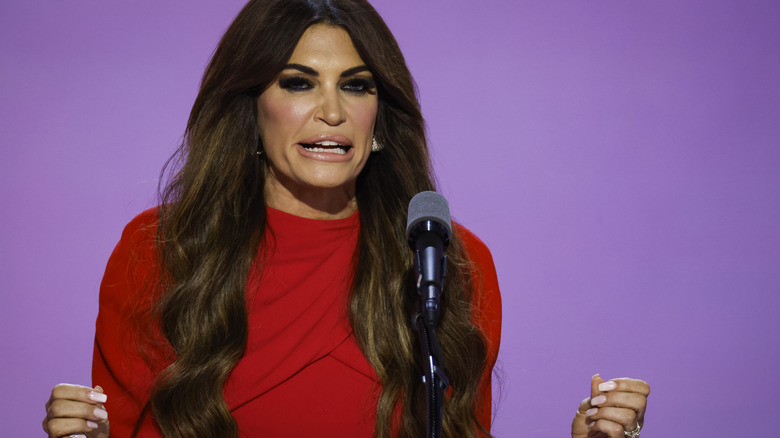 Kimberly Guilfoyle delivering a speech on stage in red dress