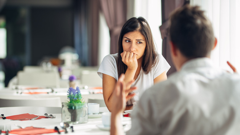 A distressed woman sitting across from partner