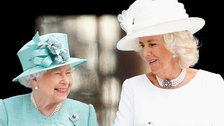 Queen Elizabeth and Camilla Parker Bowles smiling at each other