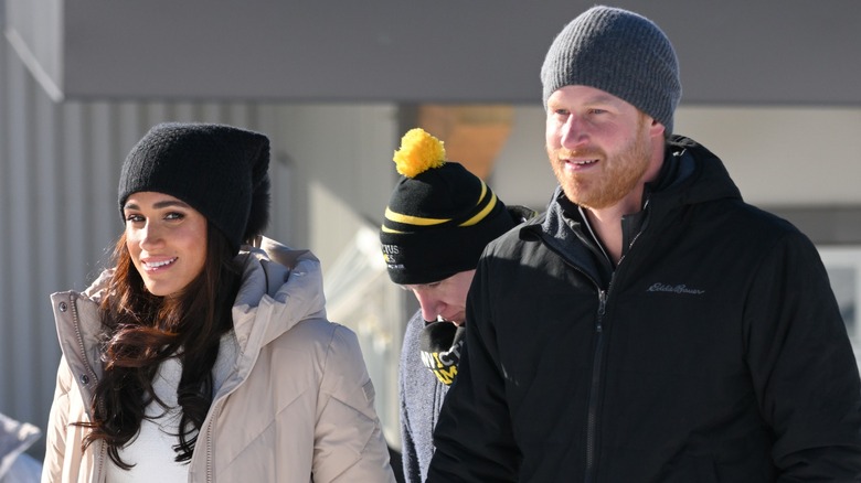 Meghan Markle Prince Harry smiling, holding hands