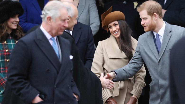 King Charles stands with Meghan Markle and Prince Harry