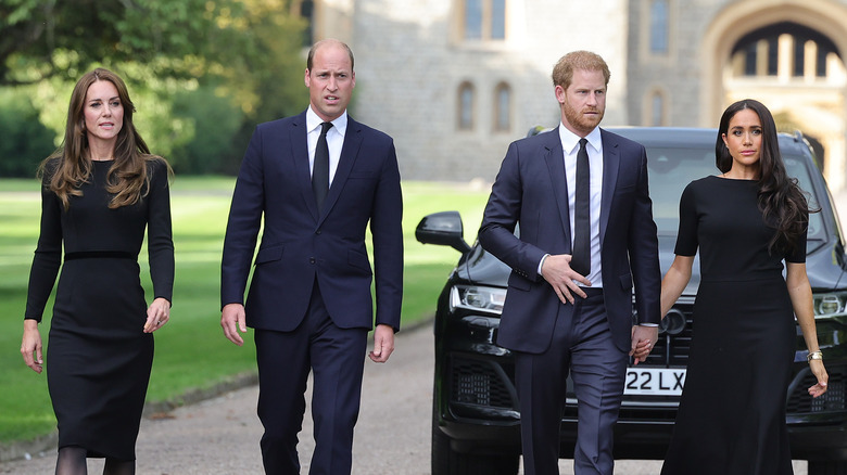 Catherine Middleton, Prince William, Prince Harry and Meghan Markle walking to greet mourners at Windsor Castle