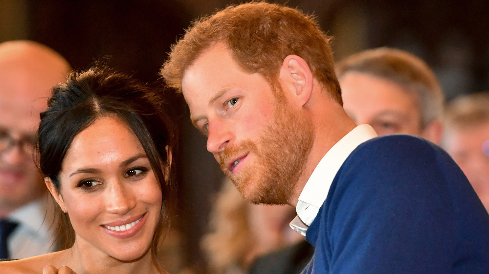 Meghan Maarkle and Prince Harry confer at an event