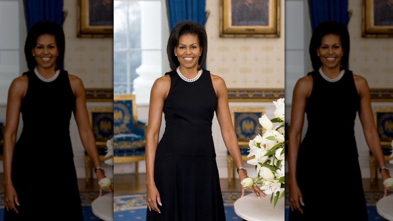 Michelle Obama in a sleeveless black dress posing for White House portrait