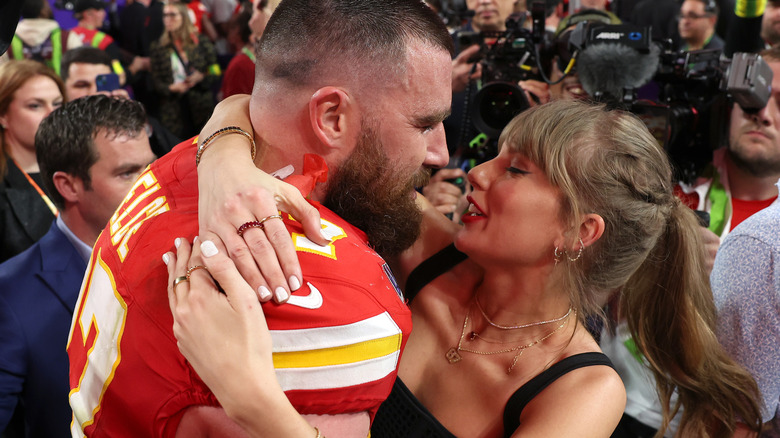 Travis Kelce and Taylor Swift embrace in a crowd