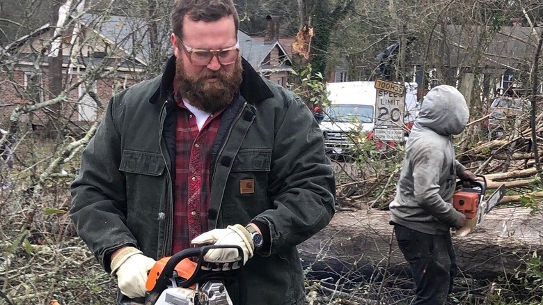 Ben uses a chainsaw during clean-up efforts