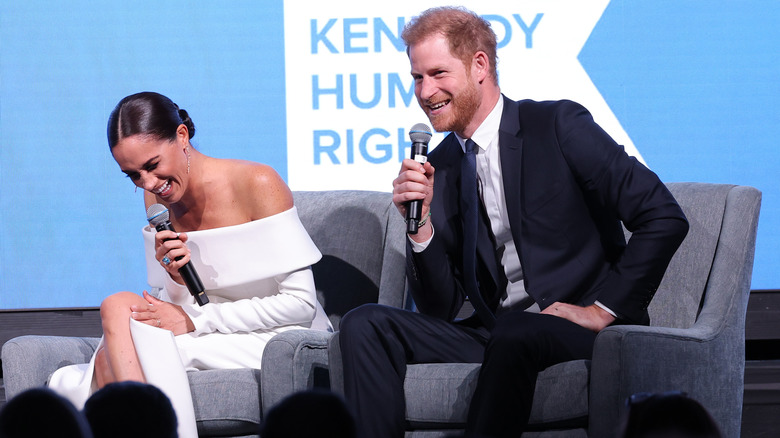 Prince Harry grinning and Meghan Markle laughing 