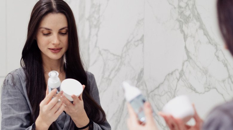 Woman evaluating skincare products