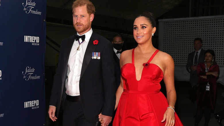 Prince Harry and Meghan Markle walking the red carpet and holding hands