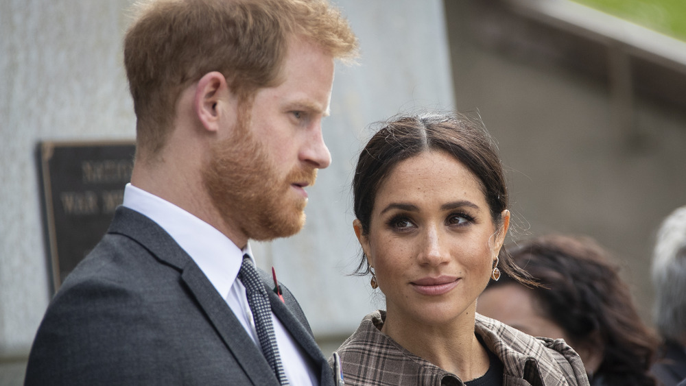 Harry with arms around Meghan 