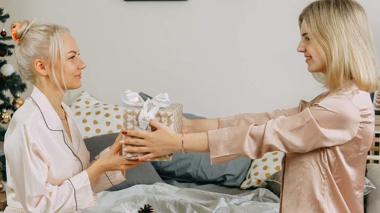 woman handing other woman present