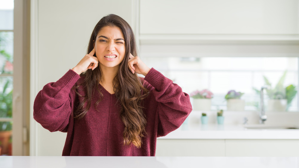 Woman looking annoyed in kitchen