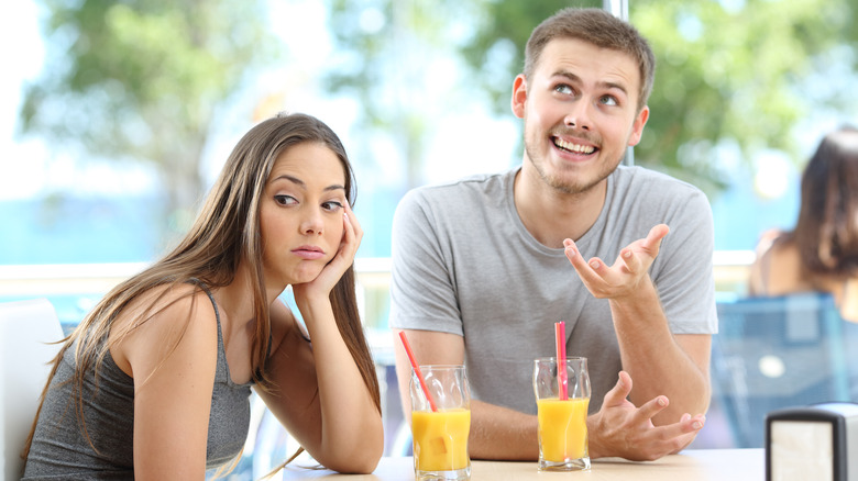 Couple on a date, man talks while woman looks away