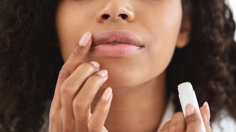 Woman applying lip balm