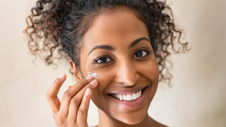 Girl applying product to face