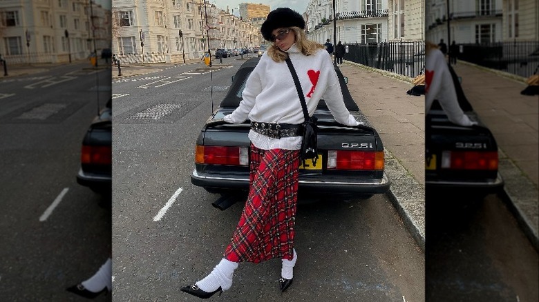 Woman in plaid skirt by car