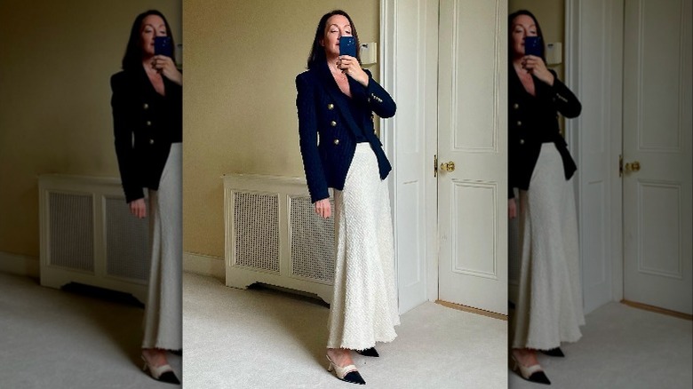 Woman in white skirt taking mirror selfie