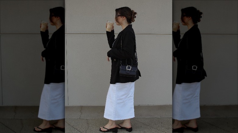 Woman drinking iced coffee in white skirt