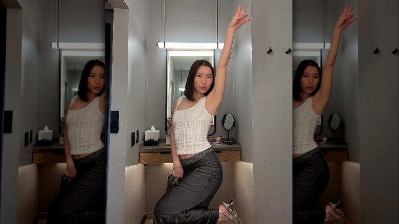 Woman in white top and gray skirt