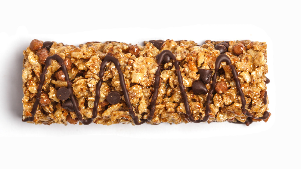 A granola bar drizzled with chocolate and added chocolate chips 